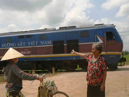 Ông Nguyễn Văn Ca (trên) và bà Ngô Thị Hoa hằng ngày tự nguyện ra đường ngang cảnh giới tàu hỏa cho người qua lại