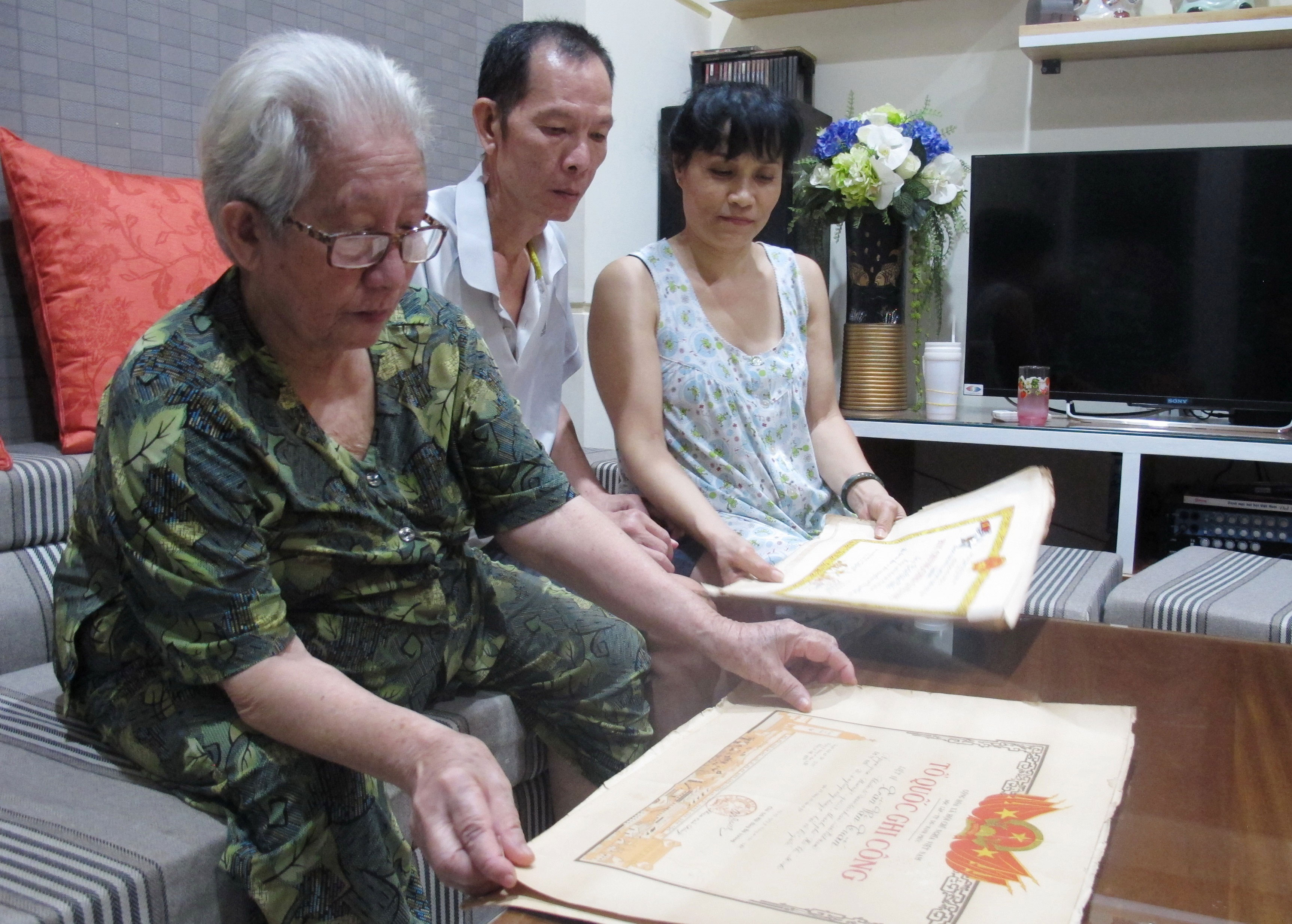 M&aacute; Nguyễn Thị Đầy v&agrave; c&aacute;c con b&ecirc;n những tấm bằng &ldquo;Tổ quốc ghi c&ocirc;ng&rdquo;  Ảnh: HỒNG NHUNG