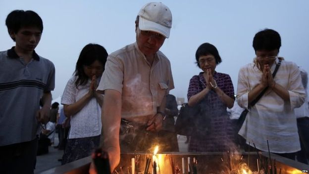 Người d&acirc;n cầu nguyện cho những người đ&atilde; chết. Ảnh: EPA