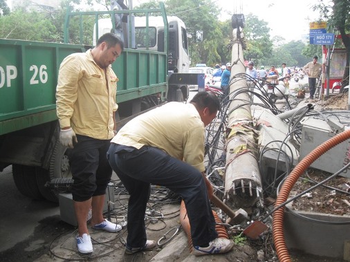 Nh&acirc;n vi&ecirc;n cáp vi&ecirc;̃n th&ocirc;ng đang xử lý 1 c&acirc;y c&ocirc;̣t đi&ecirc;̣n bị đ&ocirc;̉ do cơn l&ocirc;́c g&acirc;y ra