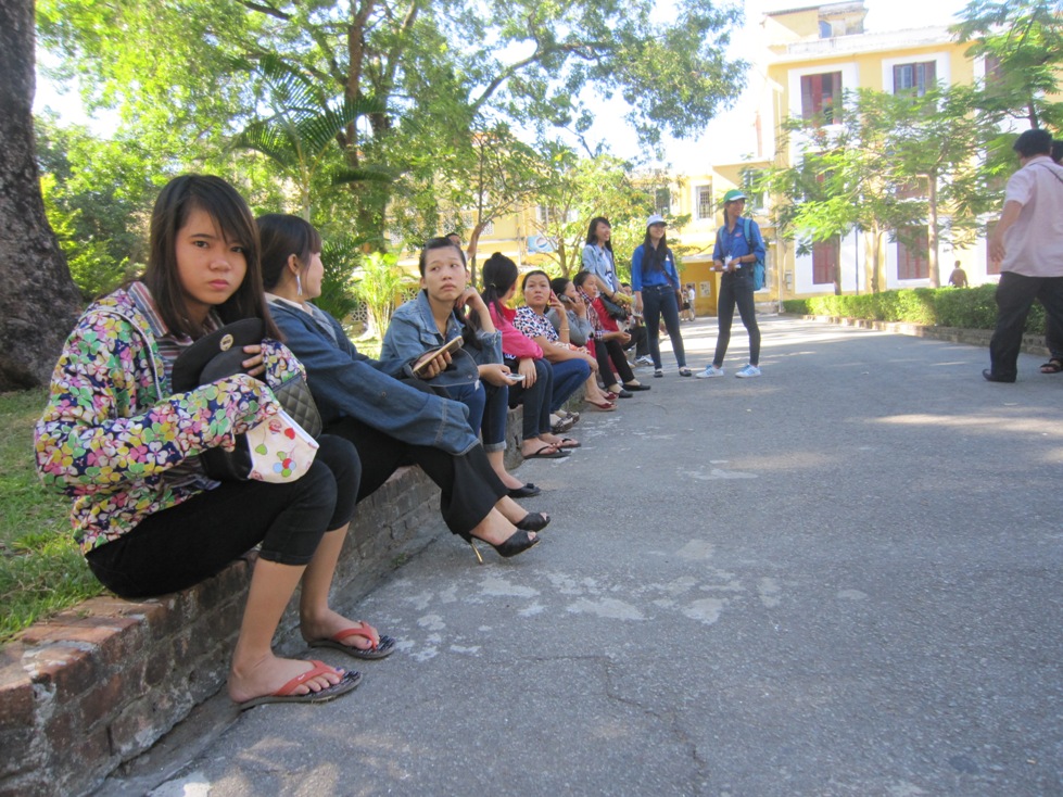 Phụ huynh ngồi chờ con em m&igrave;nh l&agrave;m thủ tục ngay tại điểm thi