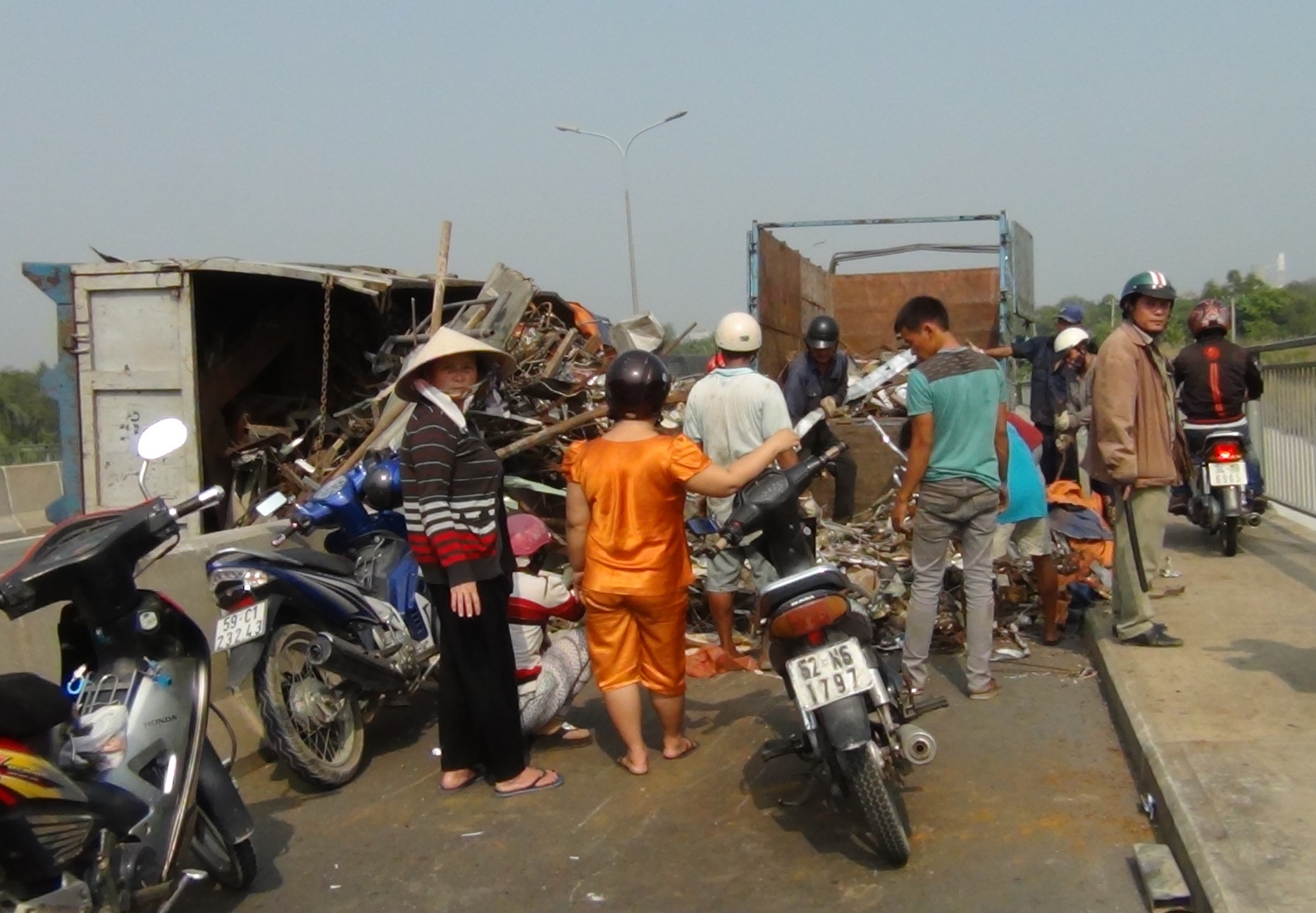 Phế liệu tr&ecirc;n chiếc xe tr&agrave;n xuống đường, chắn ngang l&agrave;n xe m&aacute;y tr&ecirc;n cầu Ph&uacute; Mỹ