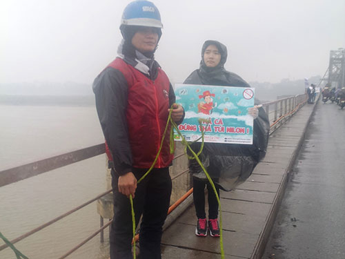 Sinh vi&ecirc;n tình nguy&ecirc;̣n trong nhóm Cá Chép đứng ở cầu Long Bi&ecirc;n hướng d&acirc;̃n, giúp đỡ người d&acirc;n thả cá m&agrave; kh&ocirc;ng thả t&uacute;i ni-l&ocirc;ng xuống s&ocirc;ng và gom rác tại c&acirc;̀u