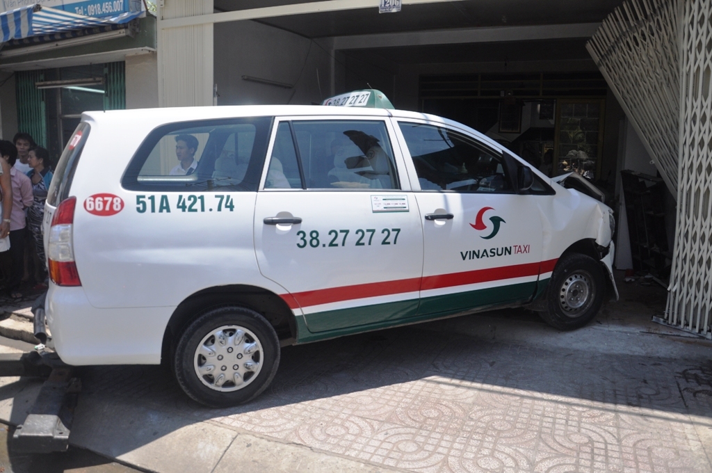 Sau c&uacute; t&ocirc;ng mạnh, chiếc xe taxi l&agrave;m thủng một mảng tường lớn căn nh&agrave; số 1206 đường Phạm Thế Hiển