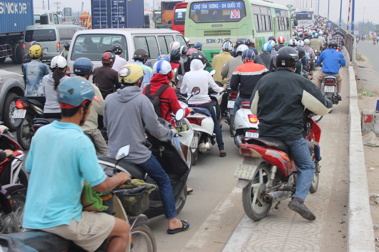 Xe m&aacute;y leo l&ecirc;n vỉa h&egrave; tr&ecirc;n cầu Rạch Chiếc để lưu th&ocirc;ng