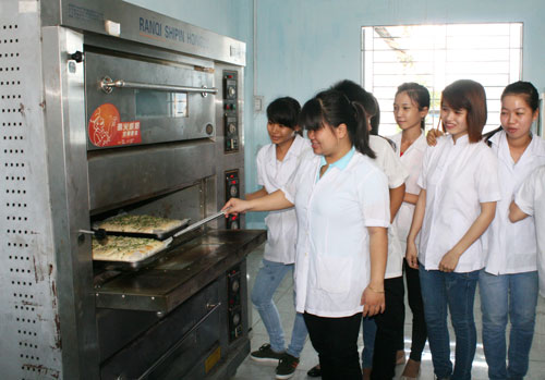 C&ocirc; L&ecirc; Ho&agrave;ng Thanh Vy, gi&aacute;o vi&ecirc;n Khoa C&ocirc;ng nghệ thực phẩm, hướng dẫn sinh vi&ecirc;n l&agrave;m b&aacute;nh trong giờ thực h&agrave;nhẢnh: LỘC TRẦN