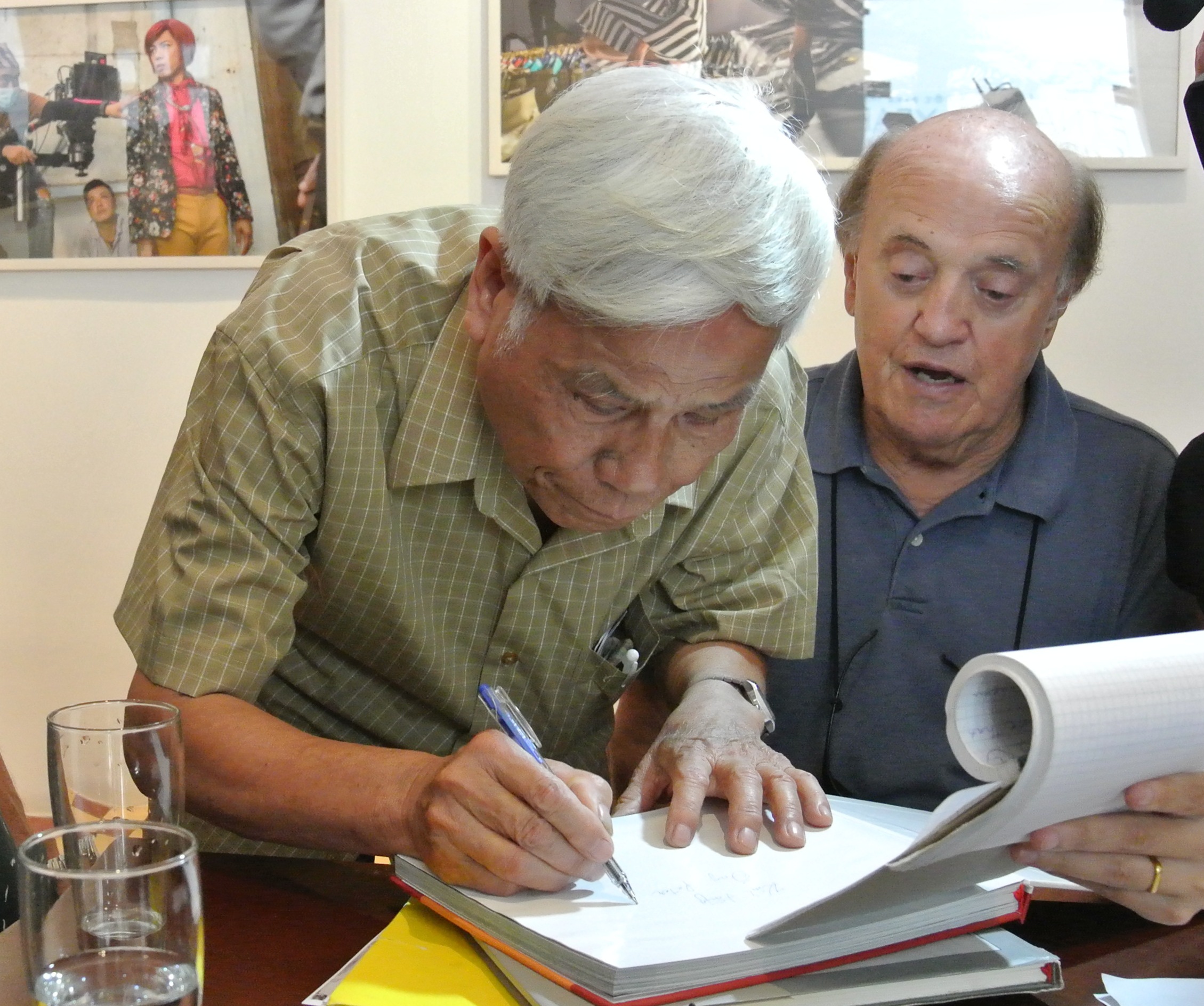 &ocirc;ng Peter Arnett đ&atilde; ki&ecirc;n quyết &ldquo;đ&ograve;i&rdquo; mua quyển s&aacute;ch ảnh ghi lại hoạt động của thanh ni&ecirc;n Việt Nam tr&ecirc;n tuyến đường Hồ Ch&iacute; Minh chi viện cho miền Nam trong kh&aacute;ng chiến chống Mỹ m&agrave; kh&ocirc;ng nhận n&oacute; như một m&oacute;n qu&agrave; tặng. Ảnh: Nh&agrave; b&aacute;o Văn Sắc của Th&ocirc;ng tấn x&atilde; Việt Nam viết lưu niệm l&ecirc;n cuốn s&aacute;ch