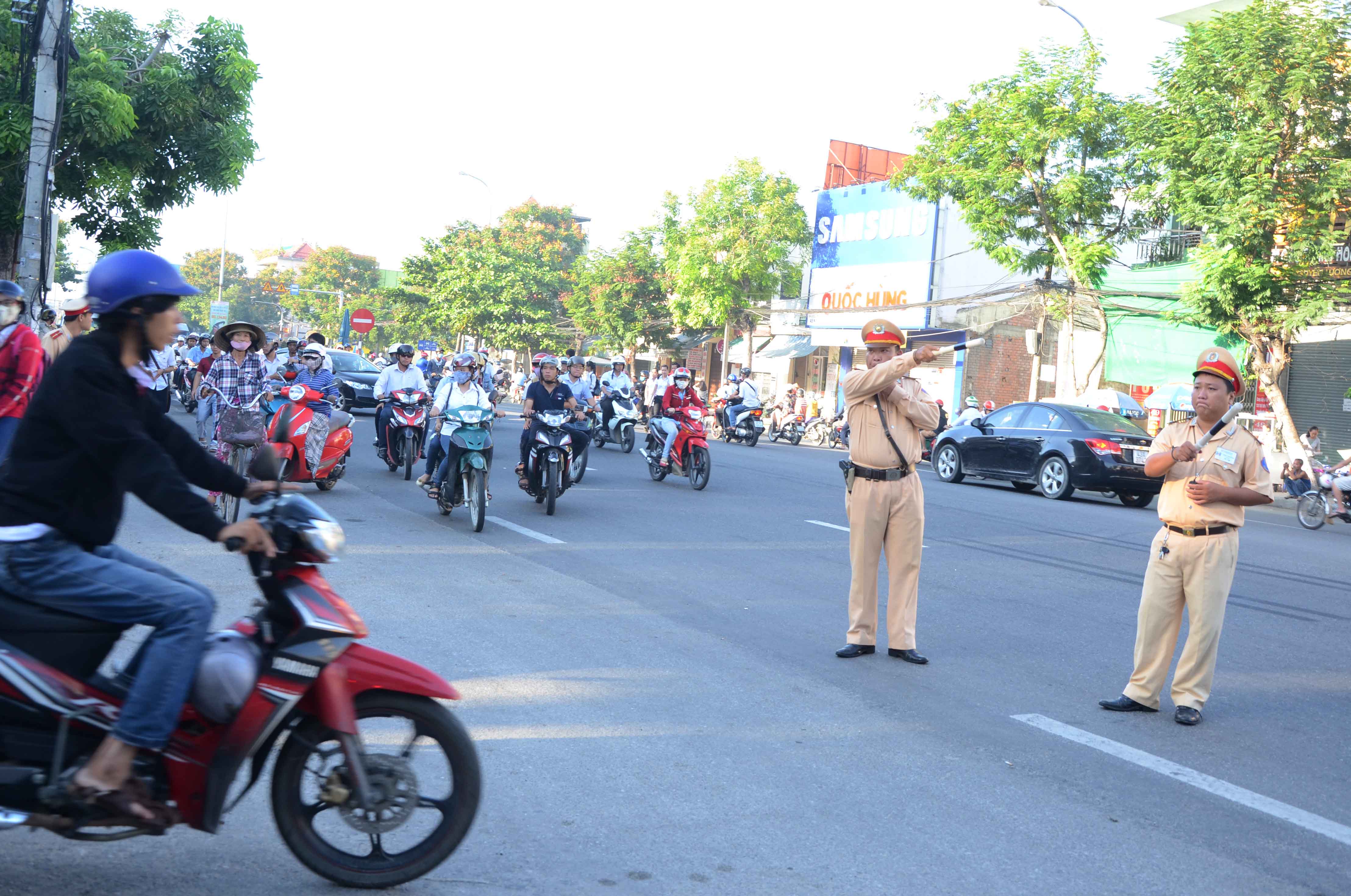 CSGT l&agrave;m nhiệm vụ ph&acirc;n luồng xe tr&ecirc;n đường T&ocirc;n Đức Thắng, trước cổng Trường ĐH B&aacute;ch khoa để tr&aacute;nh kẹt xe trước giờ diễn ra kỳ thi THPT quốc gia
