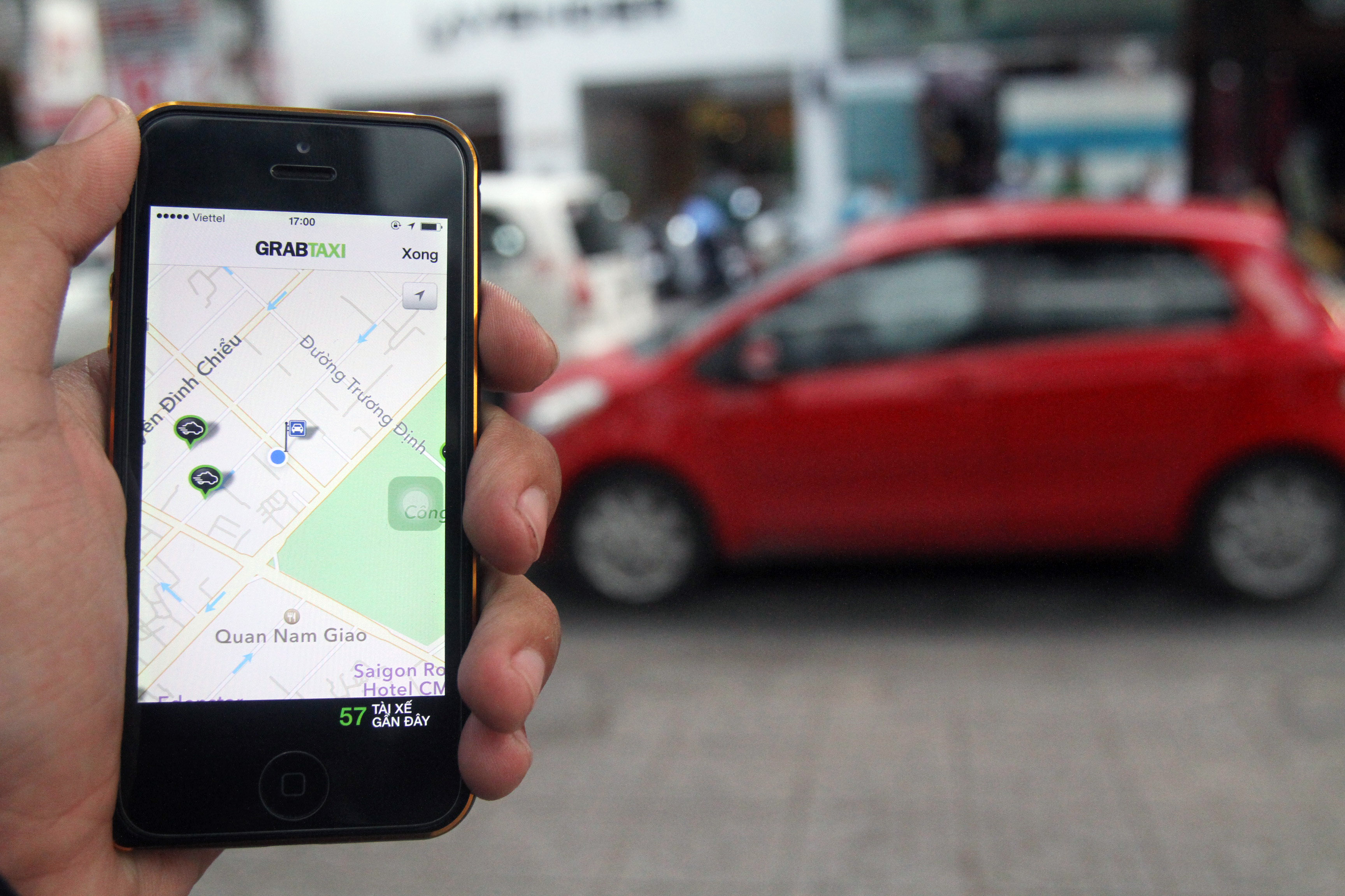 Gọi GrabTaxi th&ocirc;ng qua phần mềm tr&ecirc;n điện thoại di động 		   Ảnh: HO&Agrave;NG TRIỀU