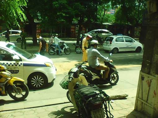 Người dân và CSGT đang cho cát vào để hút số dầu đổ ra đường