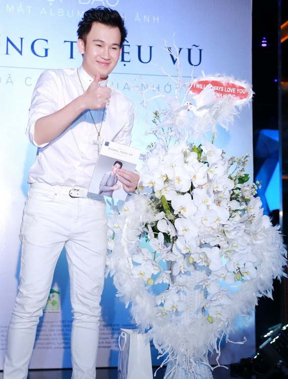 Dương Triệu Vũ b&ecirc;n lẵng hoa h&igrave;nh tr&aacute;i tim kết bằng lan trắng v&agrave; l&ocirc;ng vũ với d&ograve;ng chữ I wil always love you được Đ&agrave;m Vĩnh Hưng gửi tới