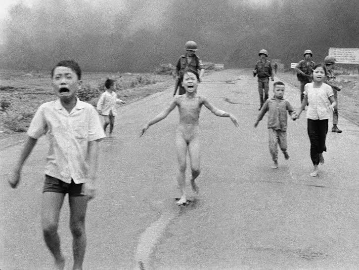 Bị bỏng nặng trong cuộc tấn c&ocirc;ng bằng bom Napalm, trẻ em chạy g&agrave;o th&eacute;t k&ecirc;u cứu dọc đường 1 gần Trảng B&agrave;ng, ph&iacute;a sau l&agrave; l&iacute;nh của Sư đo&agrave;n 25 của Việt Nam Cộng h&ograve;a ng&agrave;y 8-6-1972. C&ocirc; b&eacute; Kim Ph&uacute;c, 9 tuổi, (ở giữa) đ&atilde; cởi quần &aacute;o bị ch&aacute;y trong khi chạy. Những trẻ em kh&aacute;c (từ tr&aacute;i) l&agrave; anh của c&ocirc; Phan Thanh T&acirc;m, người bị mất một mắt v&agrave; Phan Thanh Phước v&agrave; anh em họ Hồ Văn Bốn v&agrave; Hồ Thị Tung. Bức ảnh n&agrave;y của Nick Ut đ&atilde; gi&agrave;nh được giải Pulitzer cho ảnh thời sự năm 1973.