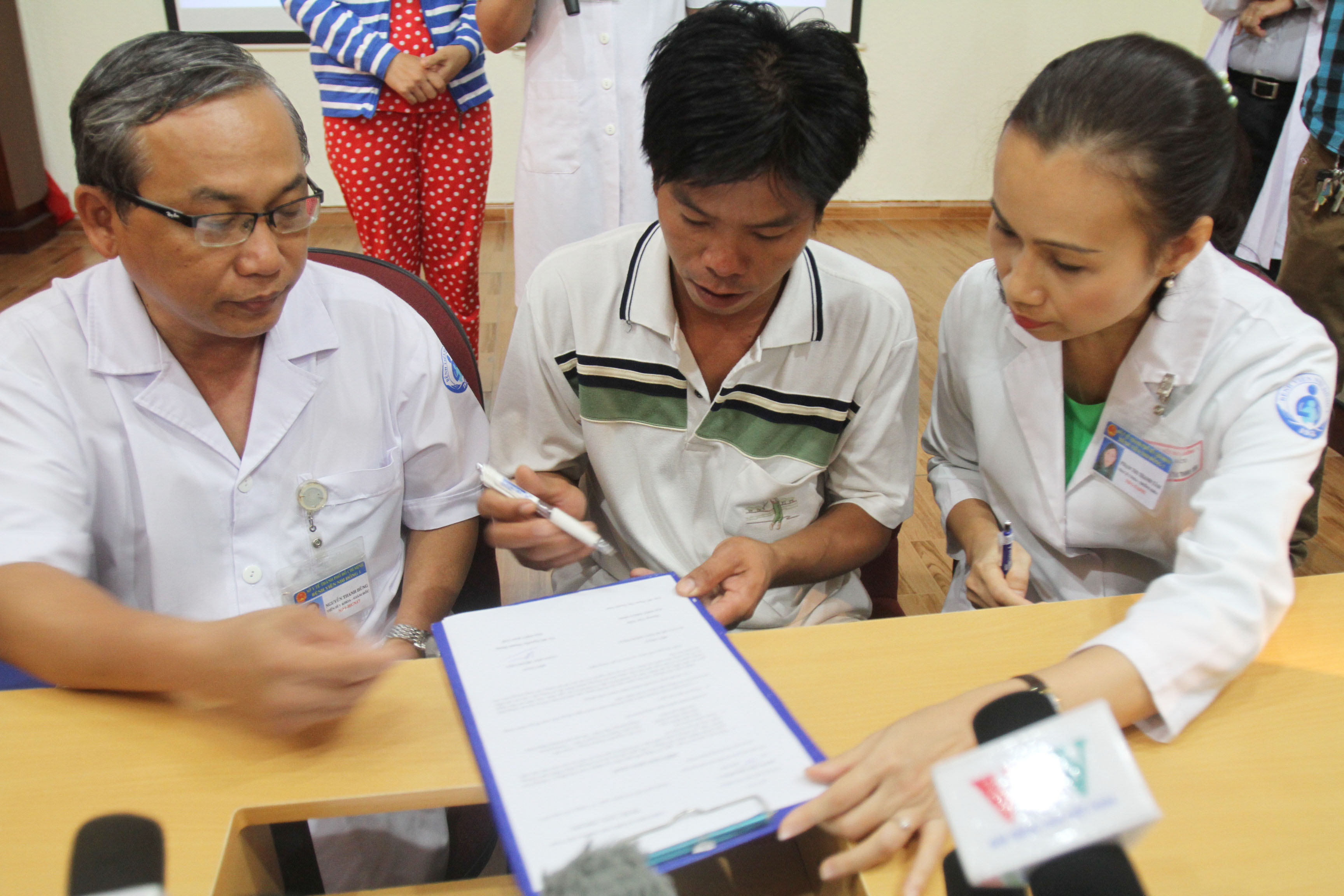 Trong khi đ&oacute;, tại Hội trường bệnh viện, BS Nguyễn Thanh H&ugrave;ng (tr&aacute;i), gi&aacute;m đốc BV, đ&atilde; trao sổ tiết kiệm 50 triệu đồng v&agrave; hơn 15 triệu tiền mặt do c&aacute;c nh&agrave; hảo t&acirc;m ủng hộ cho cha ch&aacute;u b&eacute; l&agrave; anh Dương Minh Tiền
