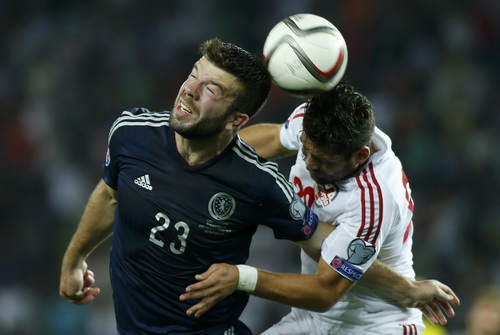 Grant Hanley (SCotland, tr&aacute;i) trước h&agrave;ng thủ Georgia