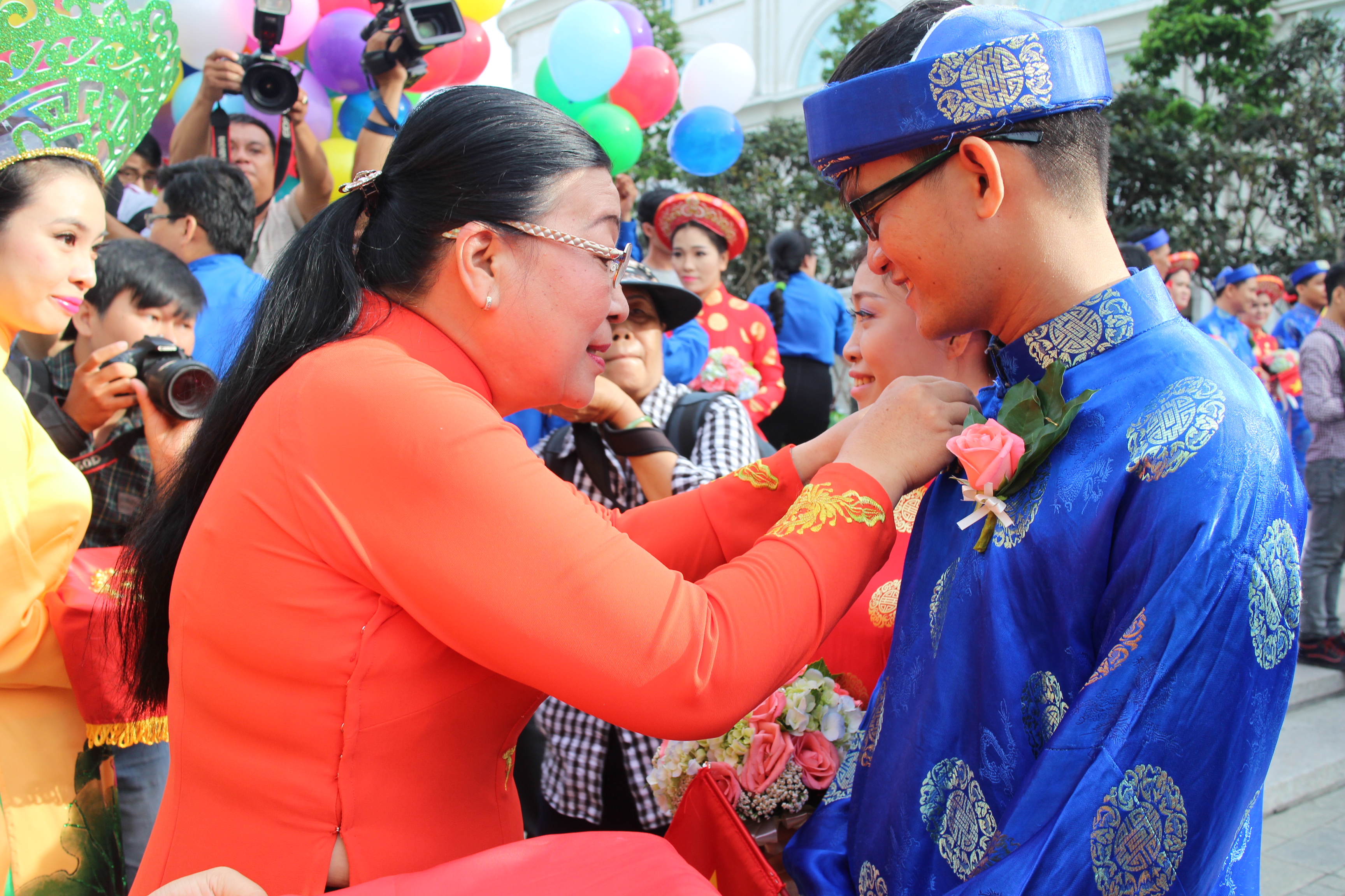 B&agrave; Nguyễn Thị B&iacute;ch Thủy, Ph&oacute; Chủ tịch LĐLĐ TP HCM, trao huy hiệu Th&agrave;nh phố cho c&aacute;c c&ocirc; d&acirc;u, ch&uacute; rẻ