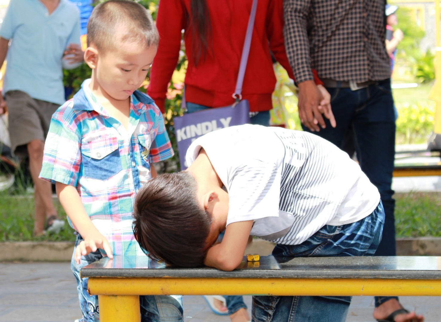 Một đứa trẻ mệt mỏi v&igrave; kh&ocirc;ng được chơi g&igrave; nhưng phải đội nắng.