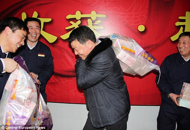 In the money: Workers in communist China are handed sackfuls of bonus money, some containing what would be several years worth of salary for westerners