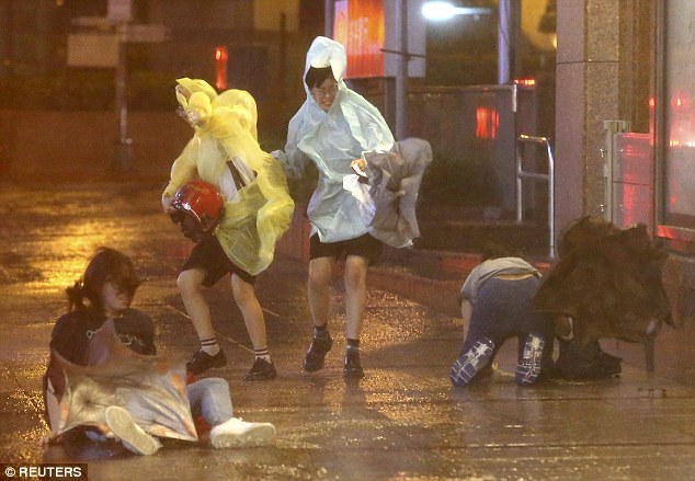 People struggling to walk against the strong winds as Typhoon Soudelor approaches Taiwan in Taipei