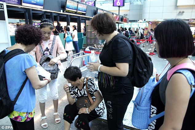 A Chinese tourist at Taiwan Airport is distraught by the news that the return flight to China was cancelled
