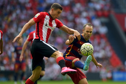 Iniesta (phải) bị hậu vệ Bilbao cản ph&aacute; pha tấn c&ocirc;ng