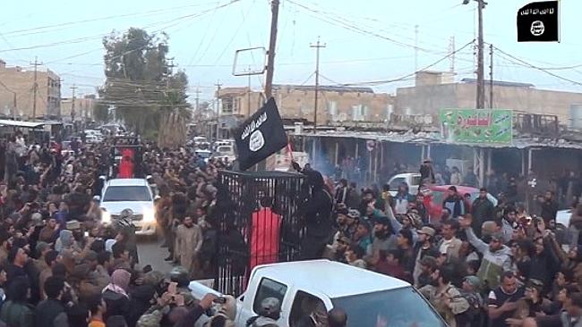 Tù binh người Kurd bị IS đóng cũi diễu hành ngoài đường. Ảnh: News.com.au