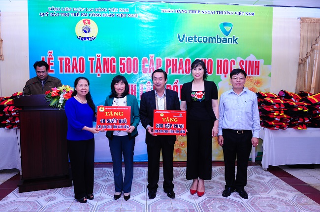 Bà Nguyễn Thị Thu Hồng (ngoài cùng bên trái) và ông Đào Minh Tuấn (ngoài cùng bên phải) cùng bà Phạm Phương Lan (thứ 2 từ phải sang) trao tượng trưng tấm biển tặng 500 cặp phao cứu sinh và 40 suất quà học bổng cho đại diện LĐLĐ tỉnh Lâm Đồng