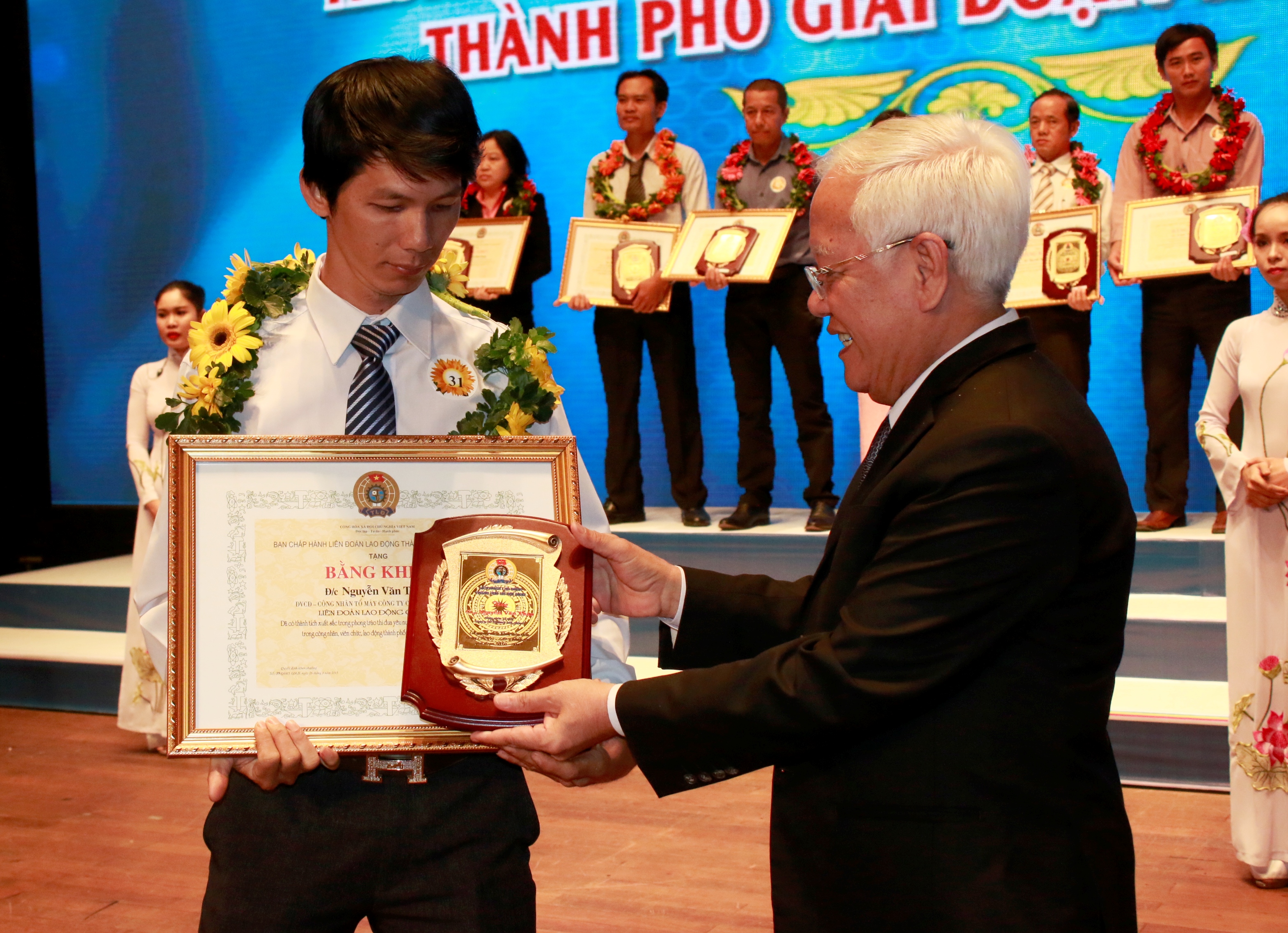 &Ocirc;ng L&ecirc; Ho&agrave;ng Qu&acirc;n, Chủ tịch UBND TP, trao biểu trưng cho CNVC-LĐ điển h&igrave;nh