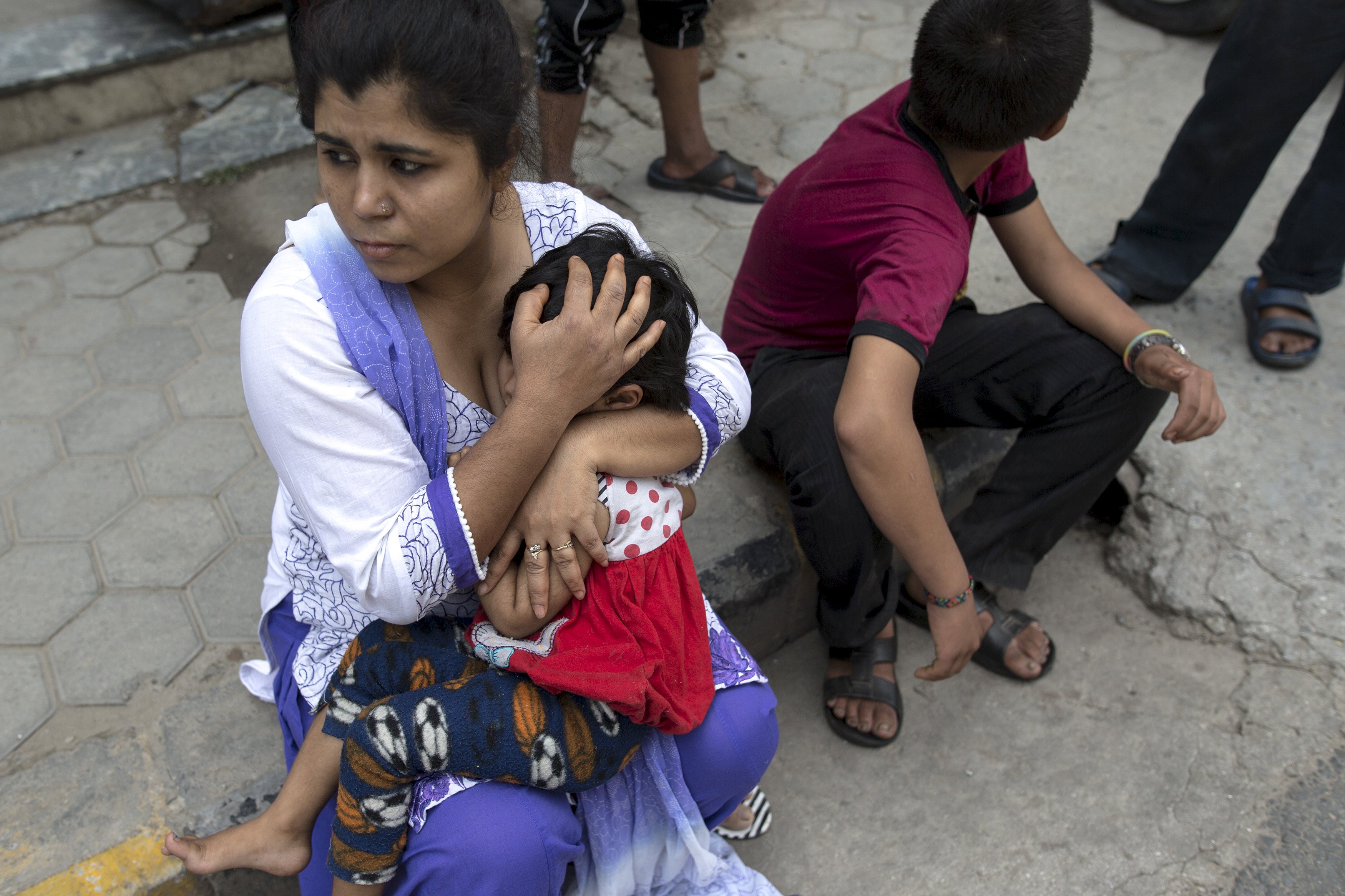 Người mẹ &ocirc;m con chạy ra đường khi động đất nổ ra ở Nepal h&ocirc;m 12-5. Ảnh: Reuters