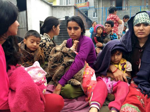 C&aacute;c b&agrave; mẹ &ocirc;m con ngồi ngo&agrave;i đường ở Kathmandu. Ảnh: Reuters