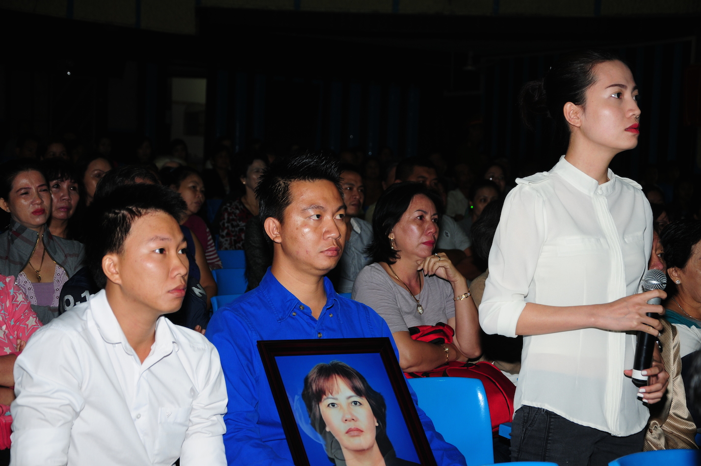 Gia đ&igrave;nh đem di ảnh của b&agrave; L&yacute; để nghe x&eacute;t xử.