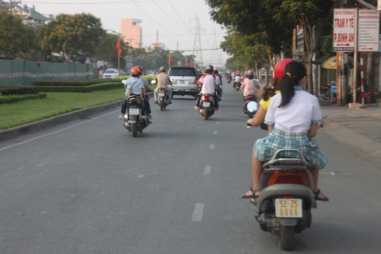 Nhiều học sinh vẫn kh&ocirc;ng đội mũ bảo hiểm khi được cha mẹ chở đi học tr&ecirc;n đường Trần N&atilde;o (quận 2)