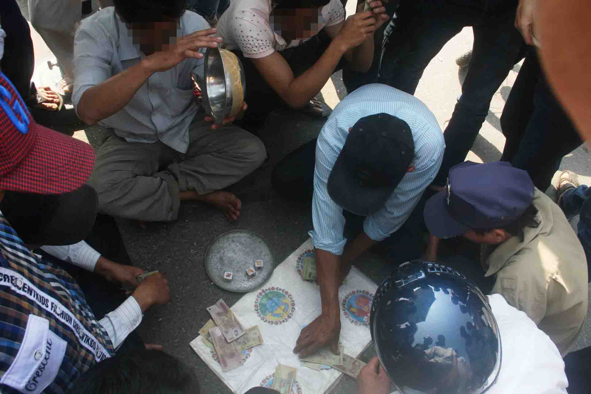 Nhiều người tập trung đánh bầu cua trong một lễ hội đua thuyền ở Quảng Nam vào sáng 25-2 Ảnh: QUANG VINH