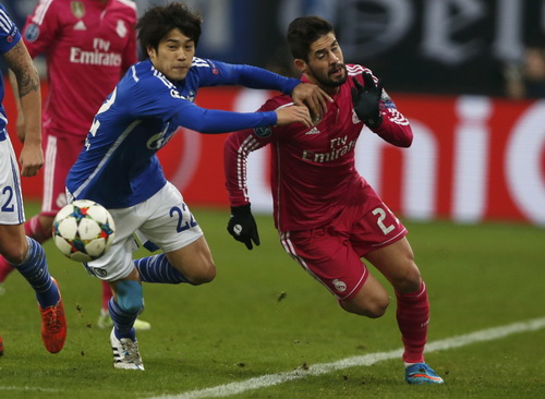 Isco (trái) đi bóng trước sự truy cản của Uchida phía Schalke