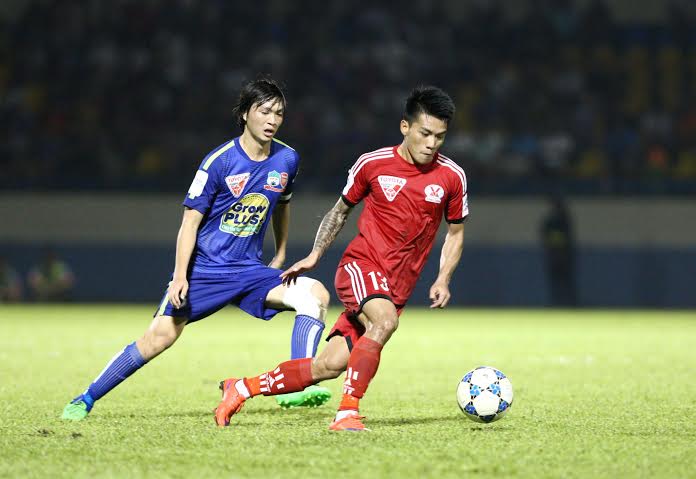 Tuấn Anh tranh bóng với Quang Hải