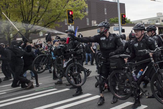 Cảnh s&aacute;t TP Seattle xịt hơi cay v&agrave;o người biểu t&igrave;nh h&ocirc;m 1-5 Ảnh: Reuters