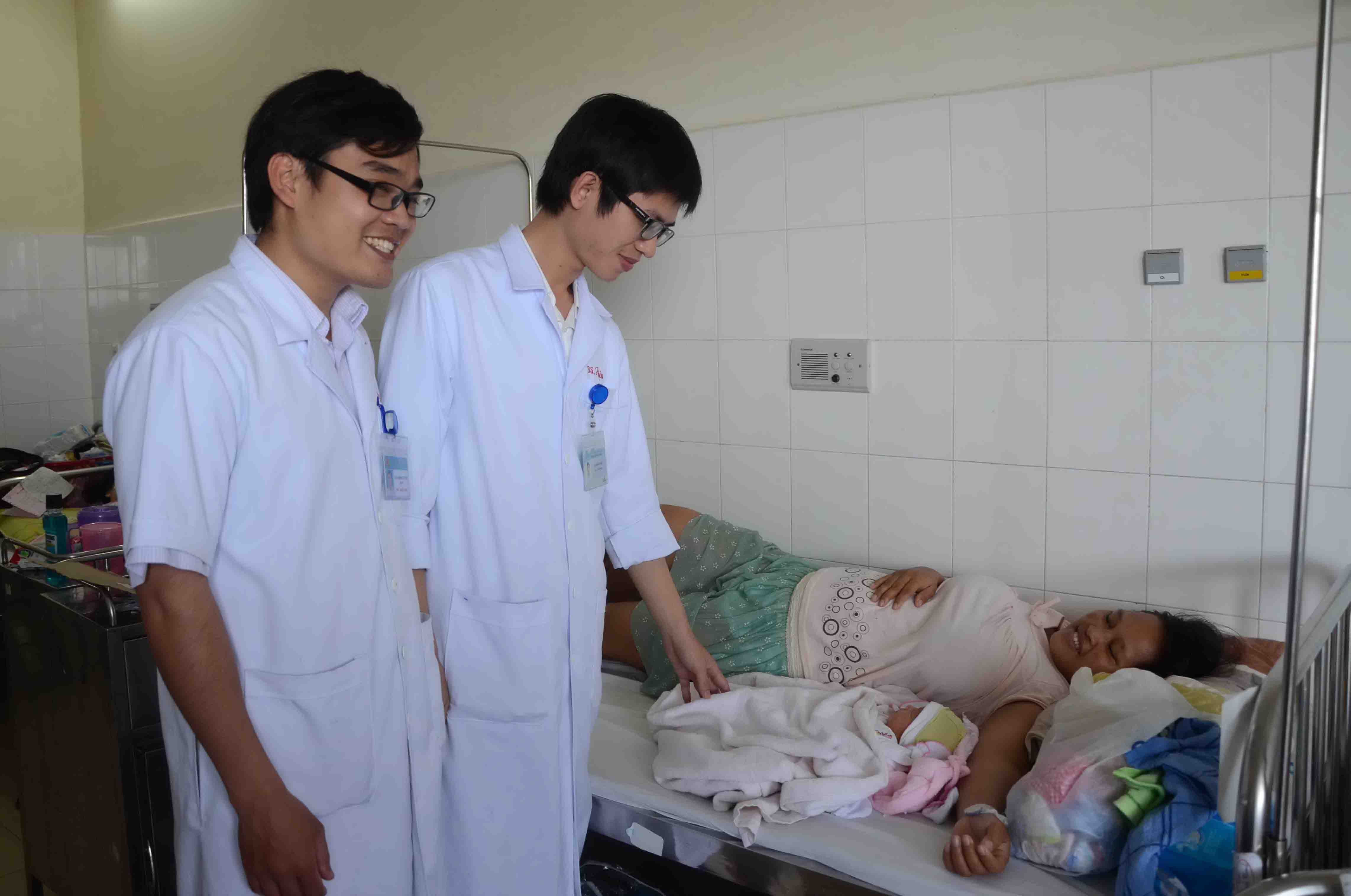 B&aacute;c sĩ Lưu Hồng Tuy&ecirc;n (tr&aacute;i) v&agrave; b&aacute;c sĩ L&ecirc; Khắc Hiệu thăm sản phụ Zơ Rum Chăm sau ca sinh mổ th&agrave;nh c&ocirc;ng