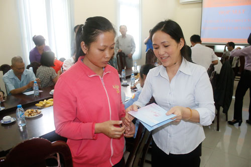 Bà Vũ Thị Ngoãn (bìa phải), Chủ tịch CĐ Sở GTVT TP HCM, trao tiền hỗ trợ cho công nhân khó khăn