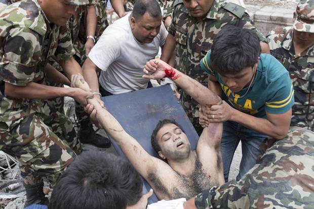 Một người đ&agrave;n &ocirc;ng được k&eacute;o ra khỏi đống đổ n&aacute;t ở TP Kathmandu. Ảnh: New York Times