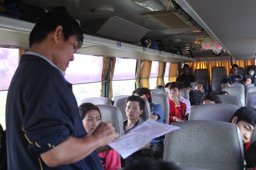 Một c&aacute;n bộ c&ocirc;n gđo&agrave;n kiểm tra v&eacute; của c&ocirc;ng nh&acirc;n trước khi xe khởi h&agrave;nh...