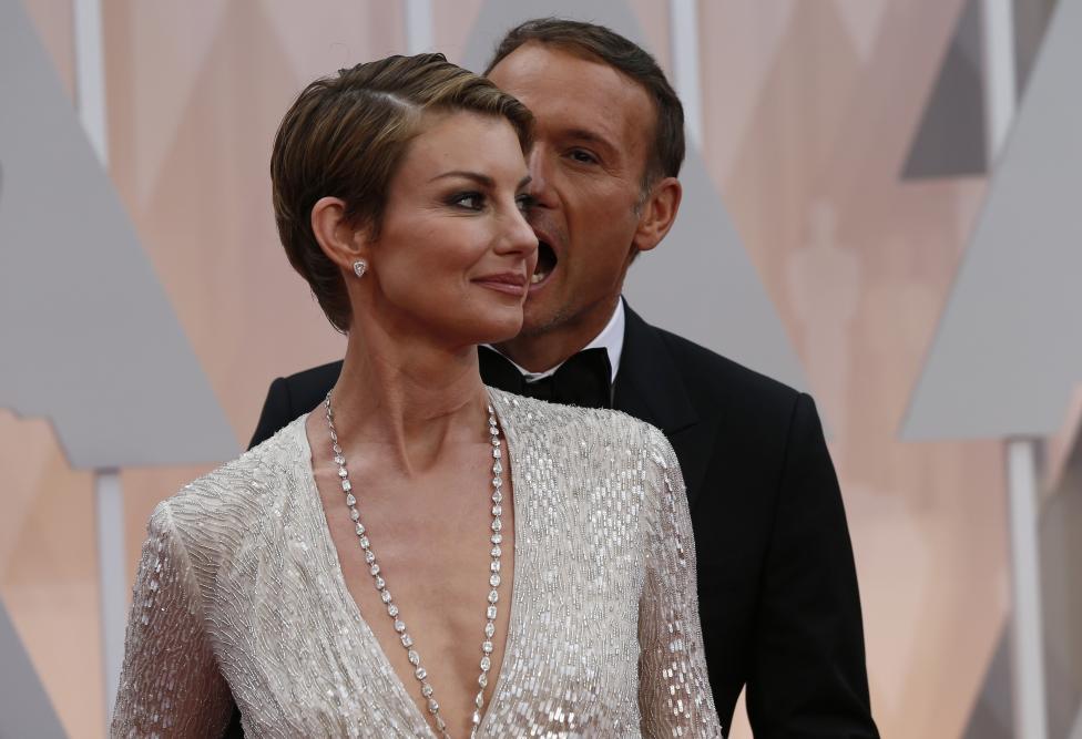 Tim McGraw l&agrave;m h&agrave;nh động như ma c&agrave; rồng chuẩn bị cắn vợ l&agrave; Faith Hill. Một kiểu tạo d&aacute;ng lạ của họ tr&ecirc;n thảm đỏ Oscar 2015