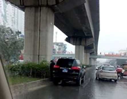 Người đàn ông đứng cạnh xe biển xanh tiểu bậy giữa đường