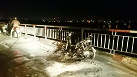 Đang đi dừng lại múa may rồi châm lửa đốt xe máy trên cầu
