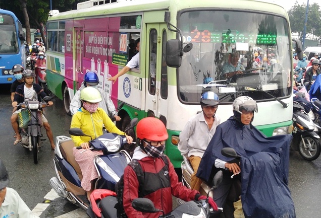 Một tiếp viên trên xe buýt phải nhô ra ngoài để xin đường lưu thông