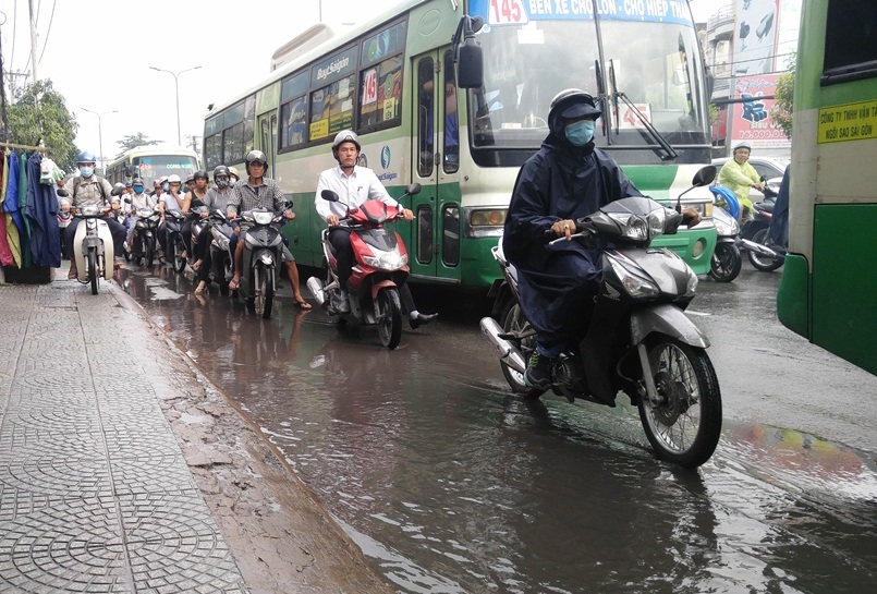 Nhiều người đi xe máy tránh vũng nước đọng trên mặt đường càng gây cảnh lộn xộn và kẹt xe