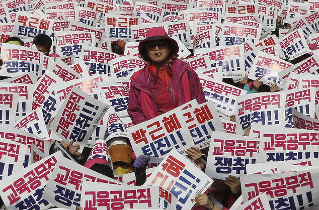 
D&ograve;ng chữ c&oacute; nội dung: B&agrave; Park Geun-hye n&ecirc;n từ chức. Ảnh: AP
