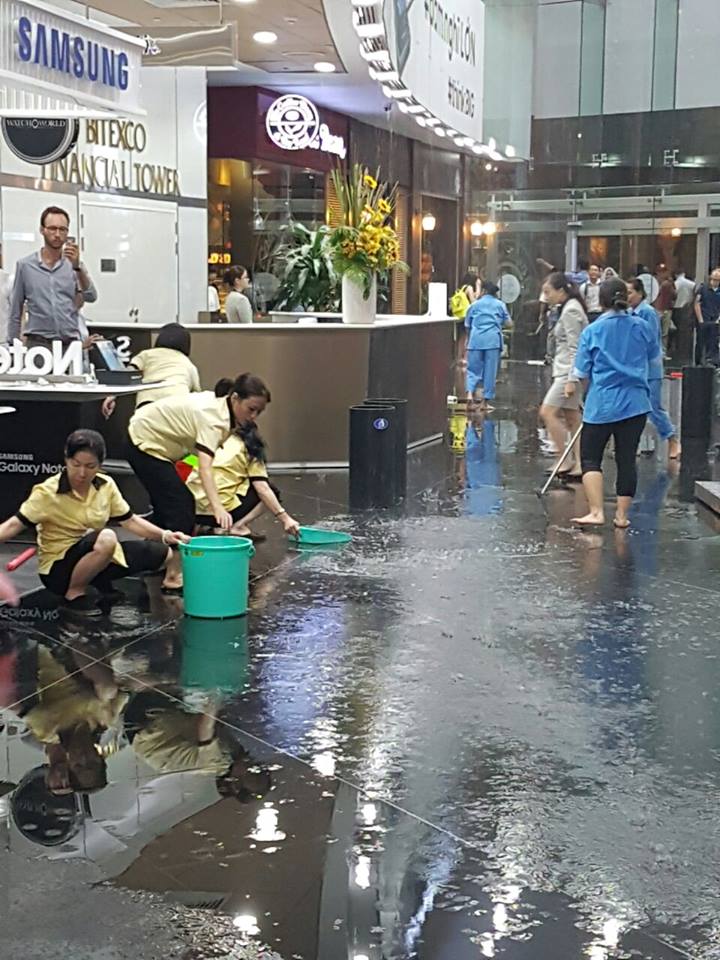 Nhiều người che dù, tránh dột trong tòa nhà Bitexco