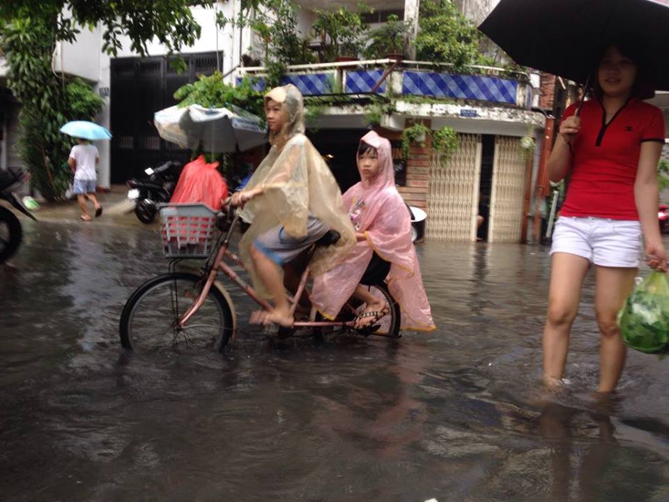 Các em học sinh phải đạp xe trong tình trạng ngập nước và ô nhiễm