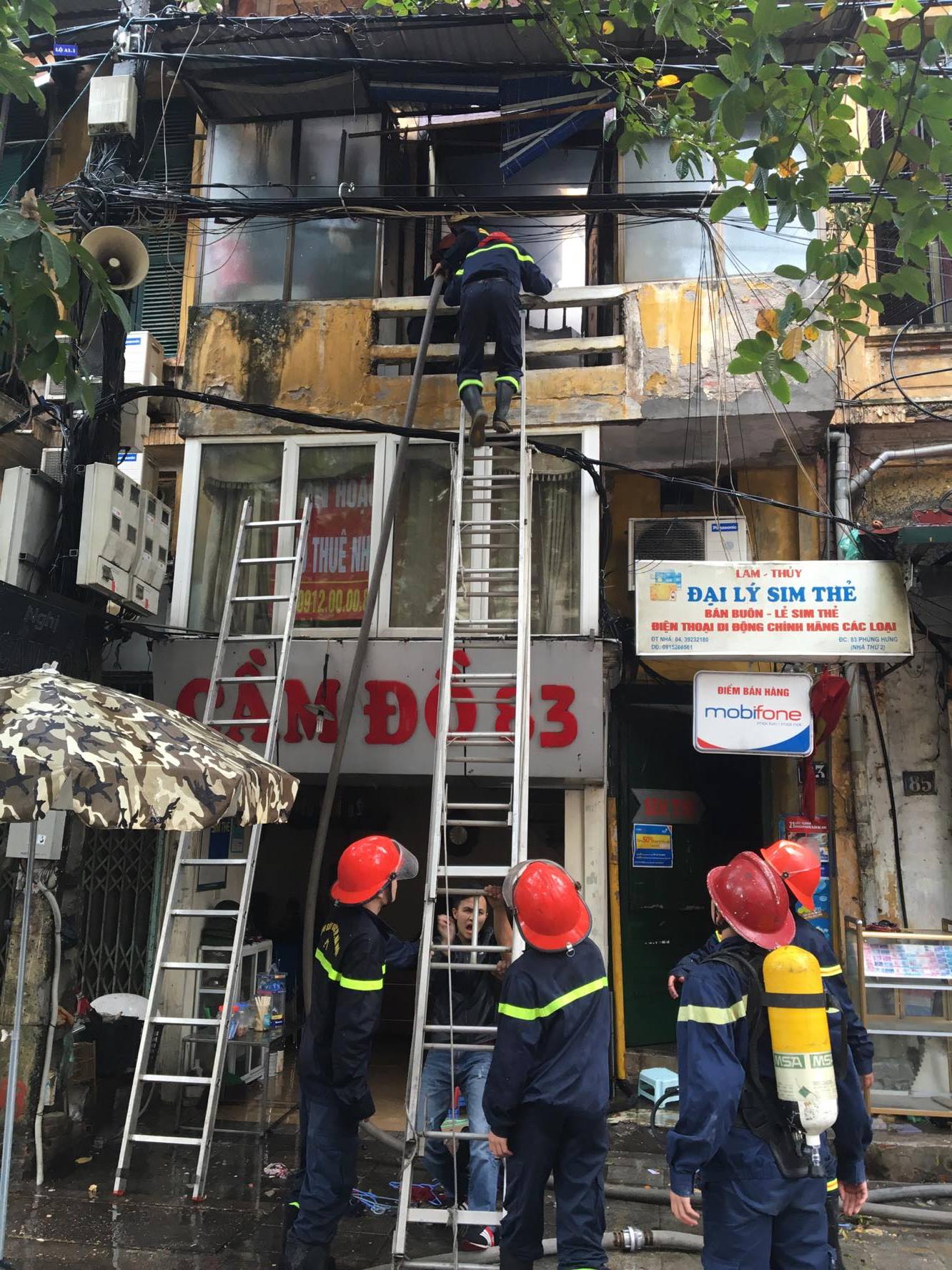 Chiến sĩ PCCC trèo lên tầng trên tiếp cận đám cháy