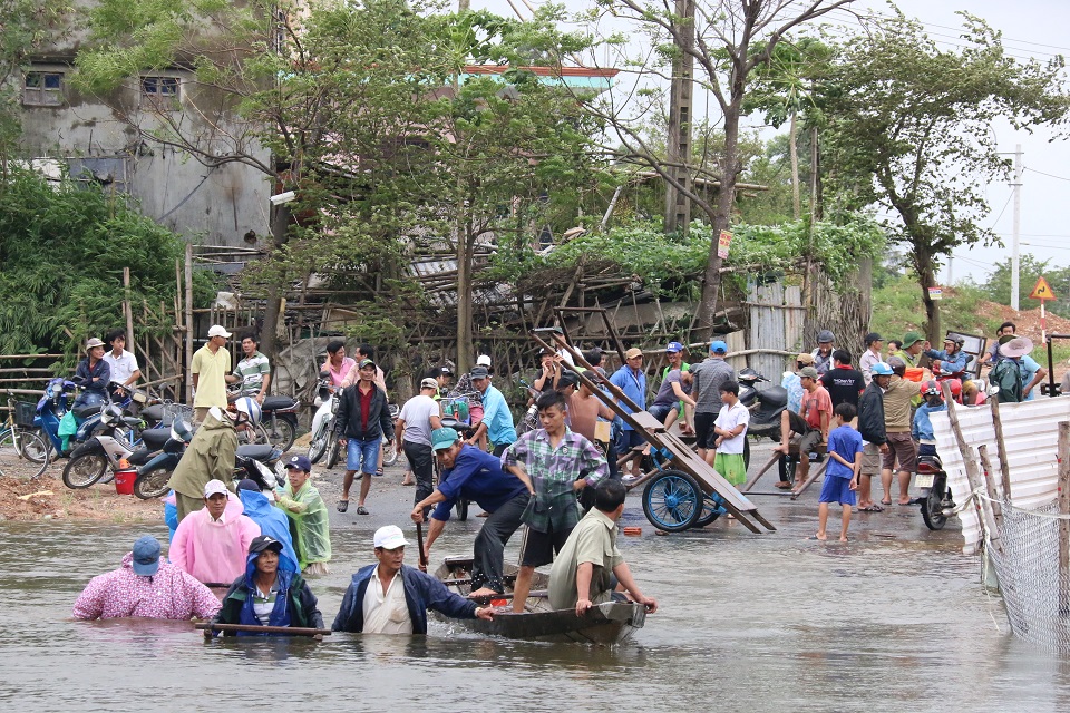 
Người d&acirc;n d&ugrave;ng ghe v&agrave; xe b&ograve; đưa xe m&aacute;y v&agrave; người sang khỏi v&ugrave;ng bị ngập
