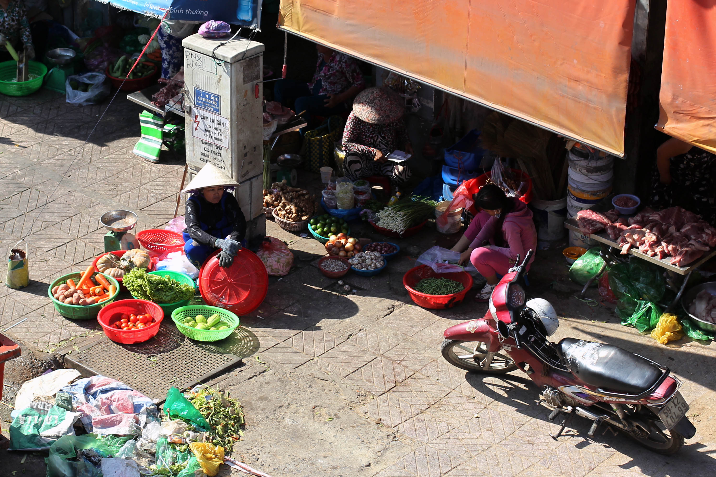 Mặc kệ bảng cảnh b&aacute;o nguy hiểm chết người, một người d&acirc;n vẫn ngồi b&aacute;n h&agrave;ng